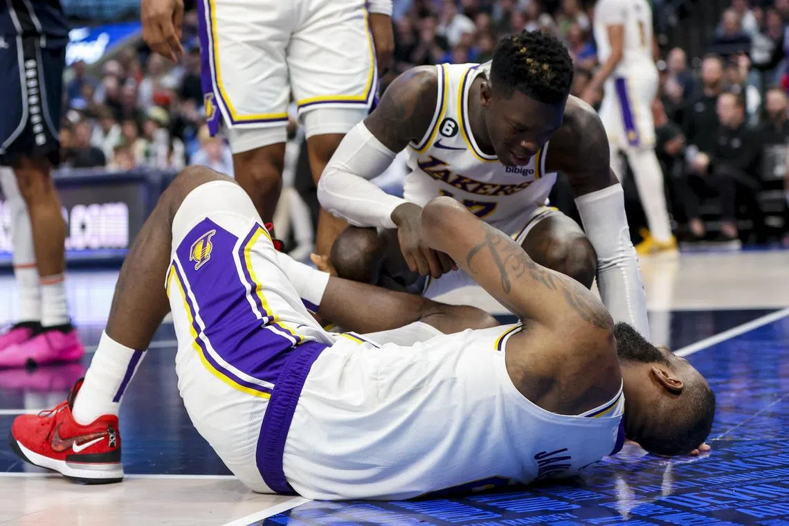 Los Angeles Lakers forward LeBron James laying on the floor injured as teammate Dennis Schroder checks on him during the game against the Dallas Mavericks at American Airlines Centre.