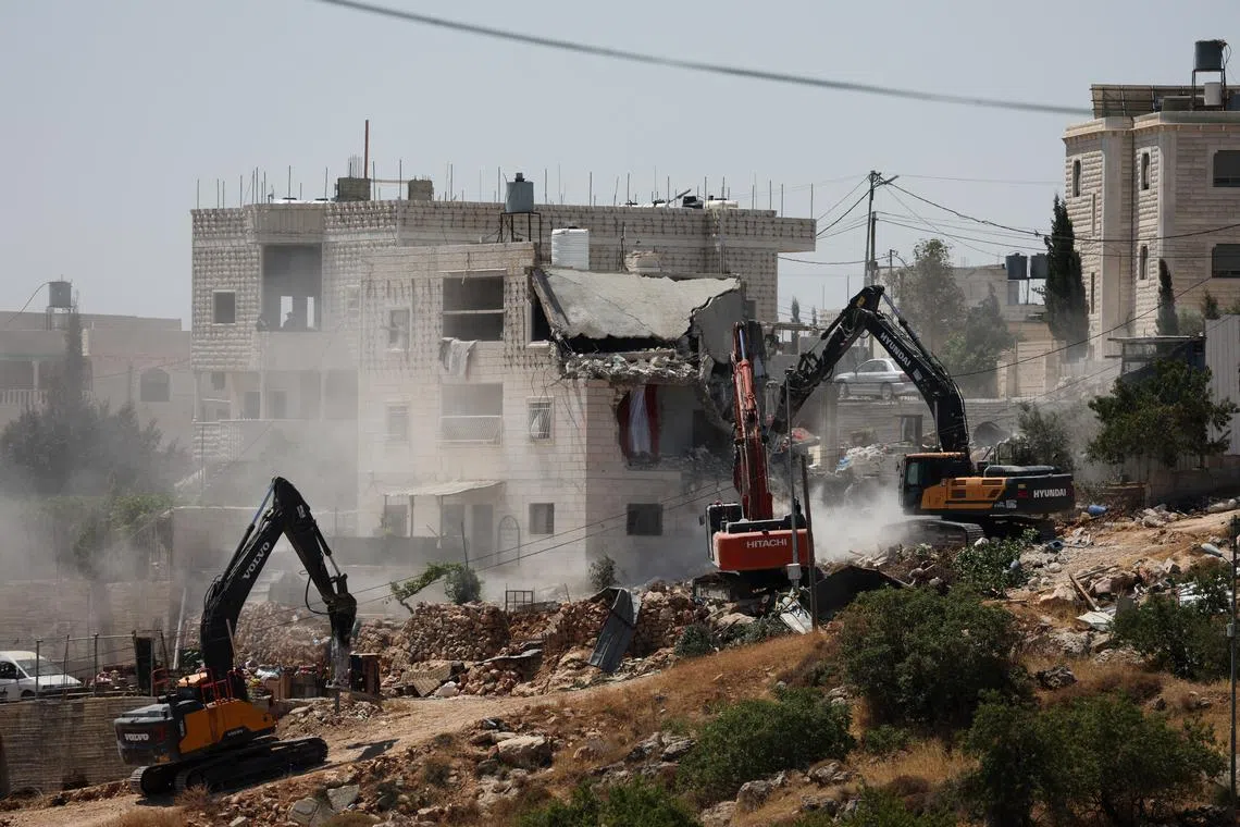 FILE PHOTO: Israeli machinery guarded by Israeli forces demolishes a Palestinian house near Hebron, in the Israeli-occupied West Bank, July 11, 2024. REUTERS/Mussa Qawasma/File Photo