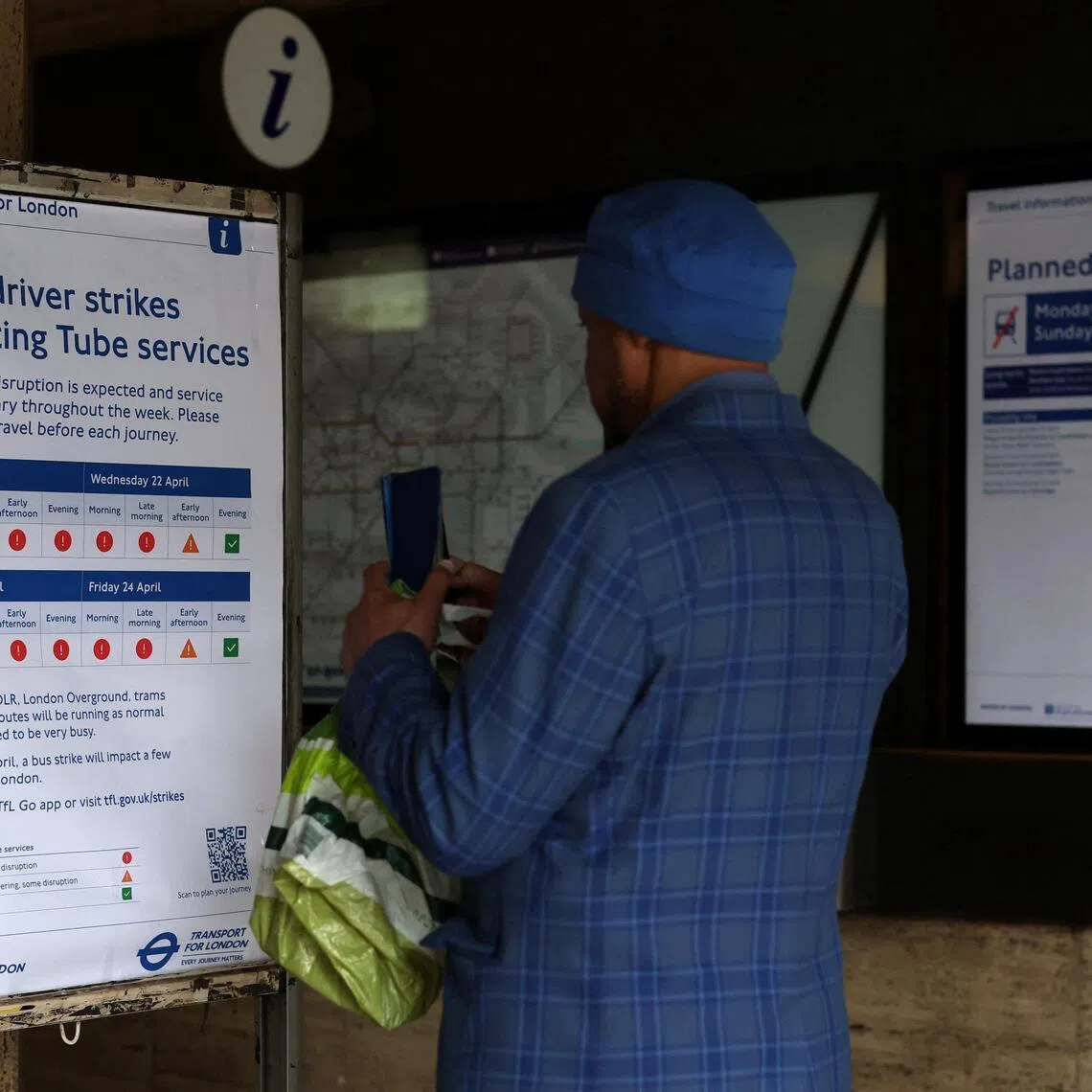 A man photographs a board displaying information about a series of 24-hour tube strikes represented by the RMT union in dispute with TFL over working patterns, on April 21.