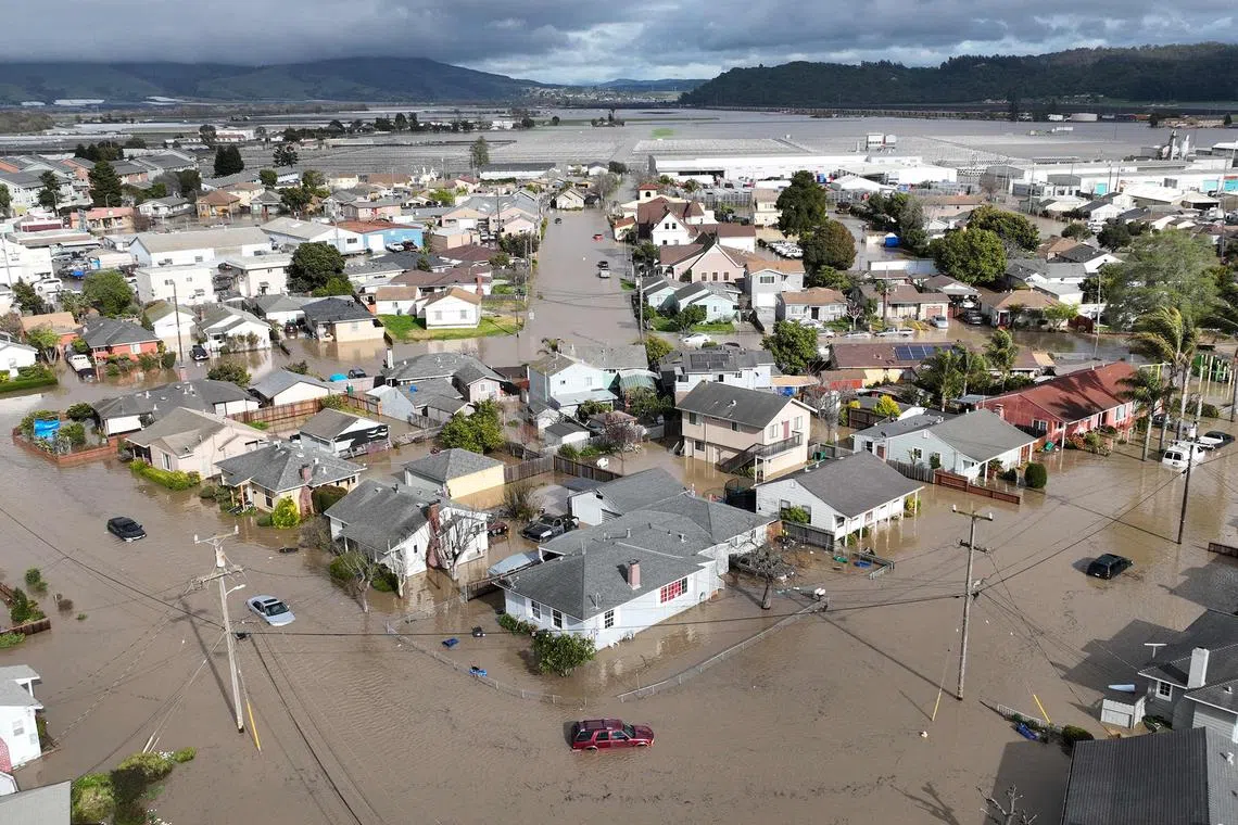 This aerial photograph shows vehicles and homes engulfed by floodwaters in Pajaro, California, March 11, 2023. 