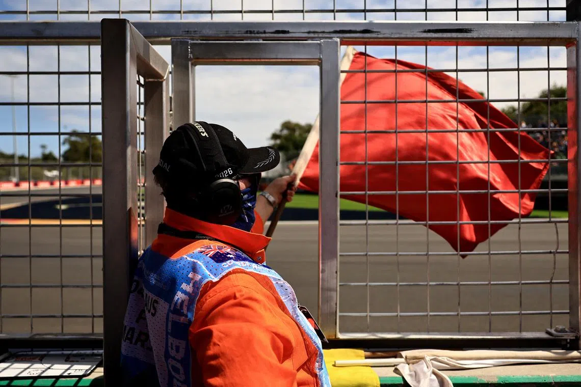 Formula One F1 - Australian Grand Prix - Albert Park Grand Prix Circuit, Melbourne, Australia - March 7, 2026 A race marshal waves a red flag after Mercedes' Kimi Antonelli crashes during the third practice session REUTERS/Mark Peterson