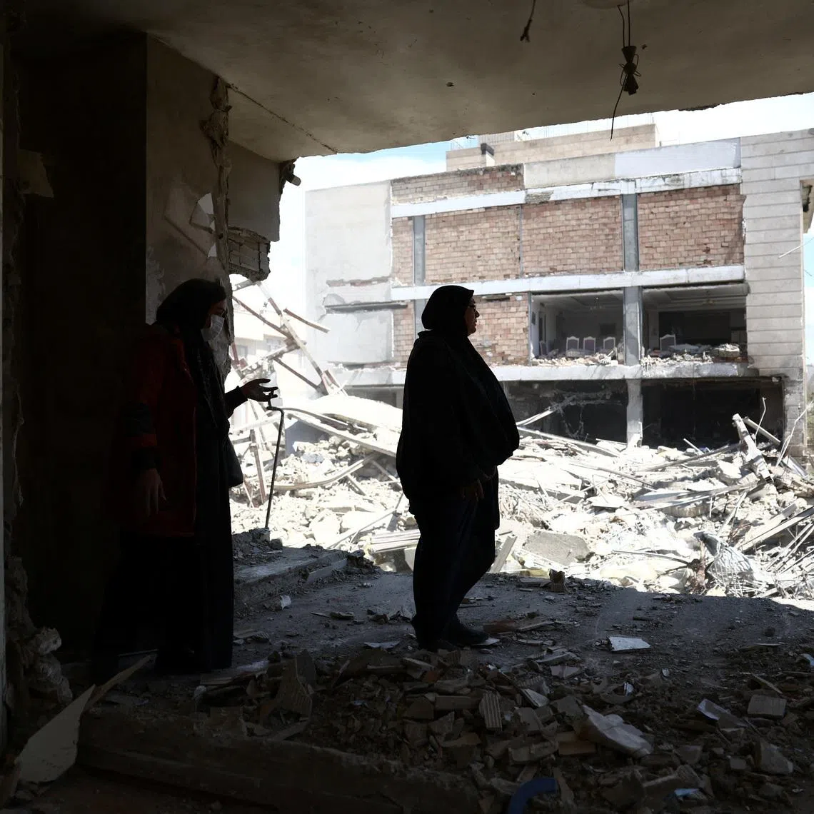 A woman stands in her brother's home, which was damaged by a strike, as the U.S.-Israeli conflict with Iran continues, in Tehran, Iran, March 30, 2026.
