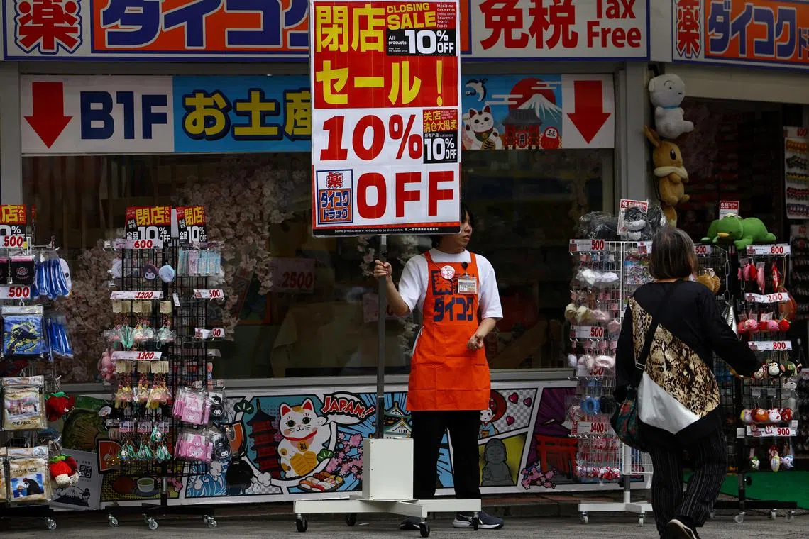 A store staff member tries to attract customers outside a store in Tokyo, Japan, May 15, 2025.  REUTERS/Issei Kato