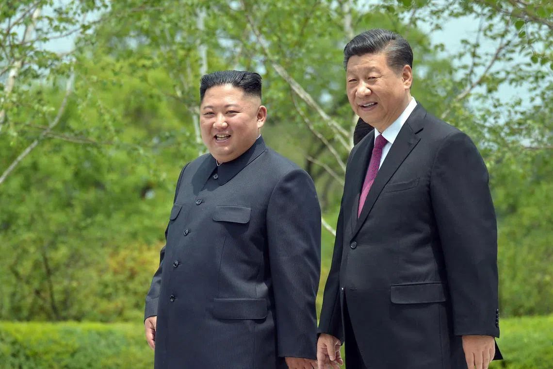 This June 21, 2019 picture shows China's President Xi Jinping (R) and North Korean leader Kim Jong Un (L) walking at the Kumsusan State Guest House in Pyongyang. 