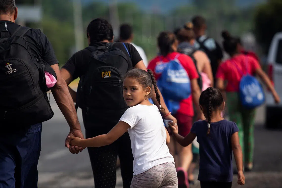 FILE PHOTO: Children hold hands with their parents as they walk with another fellow migrants in a caravan to cross the country to reach the U.S. border, as regional leaders gather in Los Angeles to discuss migration and other issues, in Huixtla, Mexico June 7, 2022. REUTERS/Quetzalli Nicte-Ha/File Photo