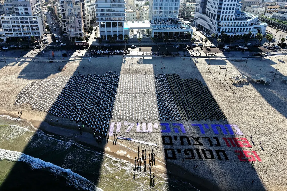 An aerial view shows people gathering around a commemorative installation marking the third anniversary of Hamas's October 7 attack on Israel, in Tel Aviv on October 7, 2026. Israel marked the third anniversary of Hamas's October 7 attack with silent tributes, new strikes on Gaza and intense political debate, weeks before elections in which the country's deadliest day will be front and centre. (Photo by Jack GUEZ / AFP)