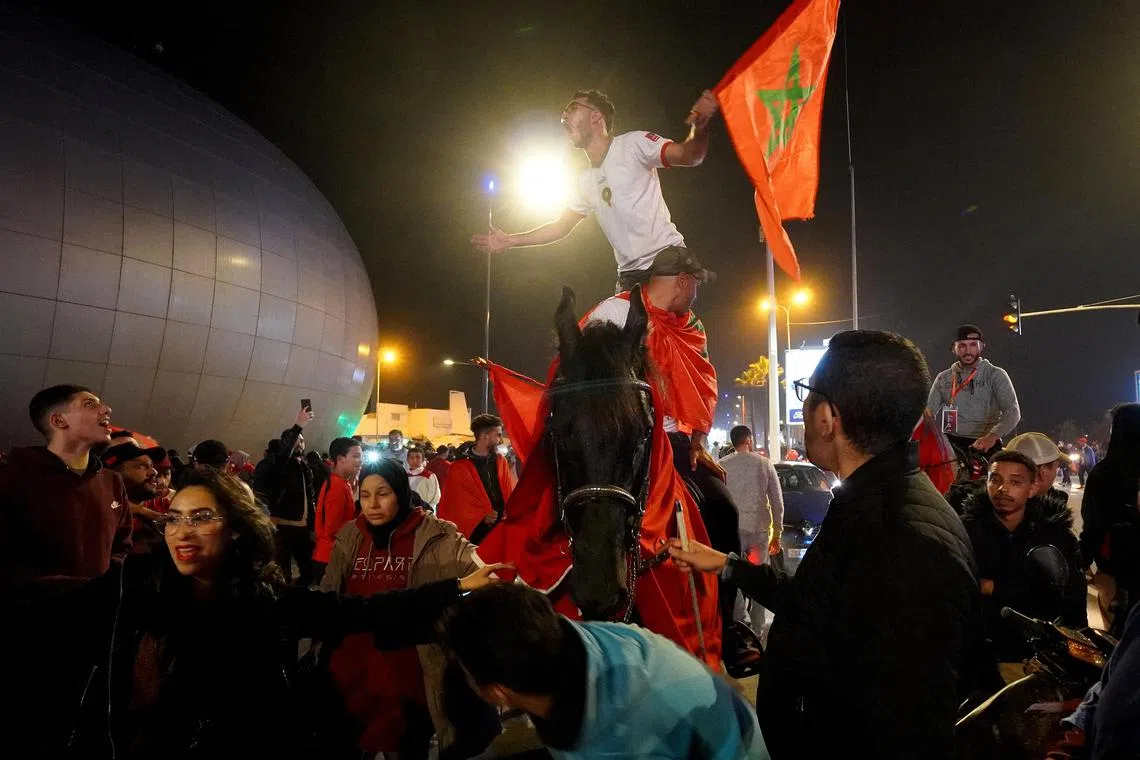 Soccer Football - FIFA World Cup Qatar 2022 - Fans in Casablanca watch Morocco v Portugal - Casablanca, Morocco - December 10, 2022
A Morocco fan rides a horse while another fan stands atop the same horse as they celebrate progressing to the semi finals REUTERS/Thami Nouas