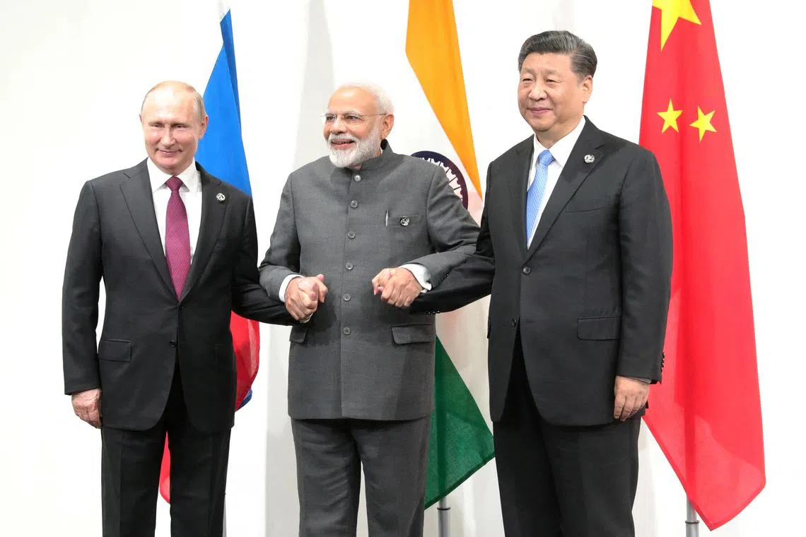 FILE PHOTO: Russia's President Vladimir Putin (L), India's Prime Minister Narendra Modi (C) and China’s President Xi Jinping pose for a picture during a meeting on the sidelines of the G20 summit in Osaka, Japan June 28, 2019. Sputnik/Mikhail Klimentyev/Kremlin via REUTERS  ATTENTION EDITORS - THIS IMAGE WAS PROVIDED BY A THIRD PARTY./File Photo