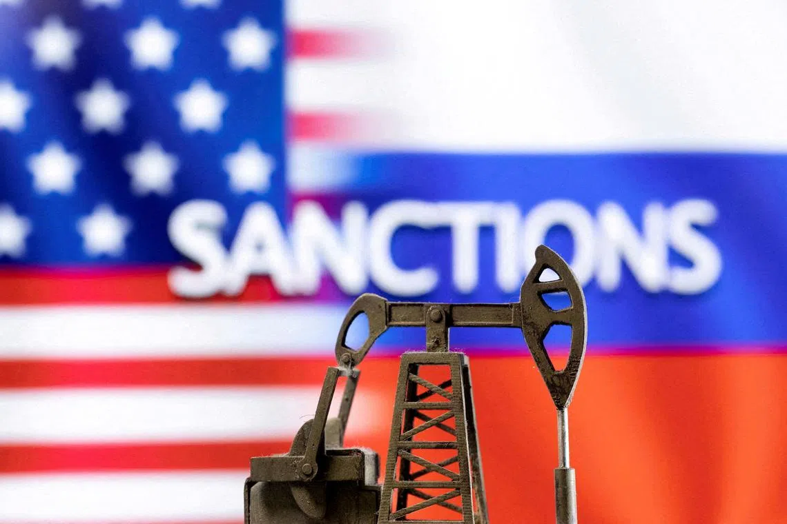 FILE PHOTO: A model of a pump jack is seen in front of the displayed word \"Sanctions,\"  U.S. and Russia flag colours in this illustration taken March 8, 2022. REUTERS/Dado Ruvic/Illustration/File Photo