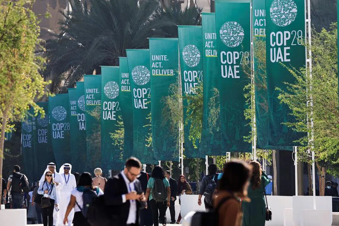 Delegates walk at the United Nations Climate Change Conference COP28 in Dubai, United Arab Emirates, December 8, 2023. REUTERS/Thaier Al Sudani/File Photo