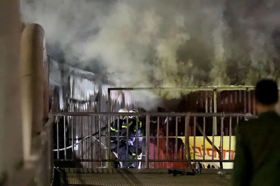 Firefighters extinguish a fire at a karaoke bar in Hanoi on Dec 19.