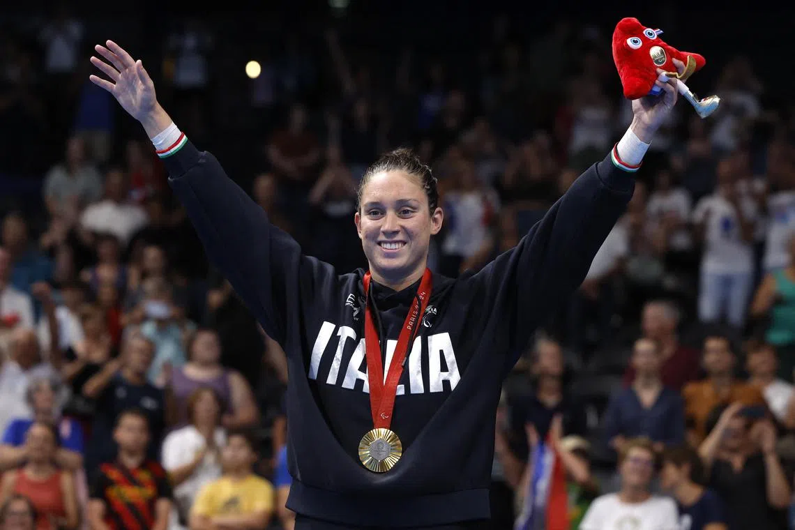 Gold medallist Carlotta Gilli of Italy celebrates on the podium after winning the women's 100m butterly S13 final at the Paris Paralympics.