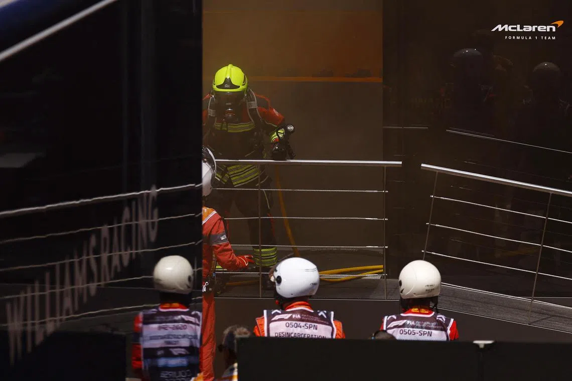 Firefighters tackling the blaze at McLaren's paddock headquarters, before final practice and qualifying for the Spanish Grand Prix.