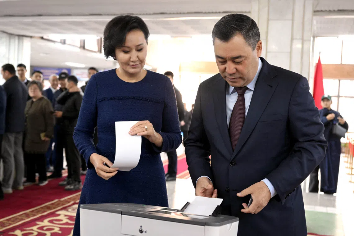 Kyrgyz President Sadyr Japarov casts his ballot as his wife Aigul Japarova stands nearby at a polling station during the snap parliamentary election in Bishkek, Kyrgyzstan November 30, 2025. Kyrgyz Presidential Press Service/Handout via REUTERS