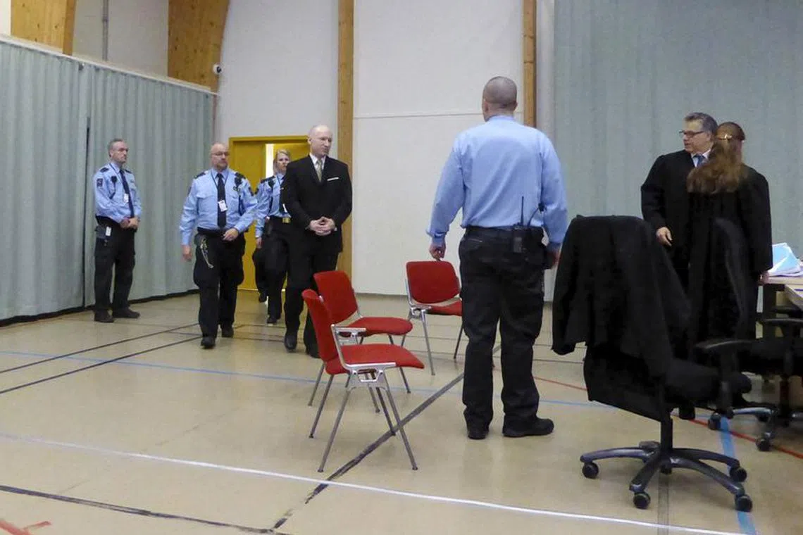 Mass killer Anders Behring Breivik (C) is escorted by prison guards as he arrives at the court room in Skien prison, Norway March 15, 2016. REUTERS/Gwladys Fouche/File Photo