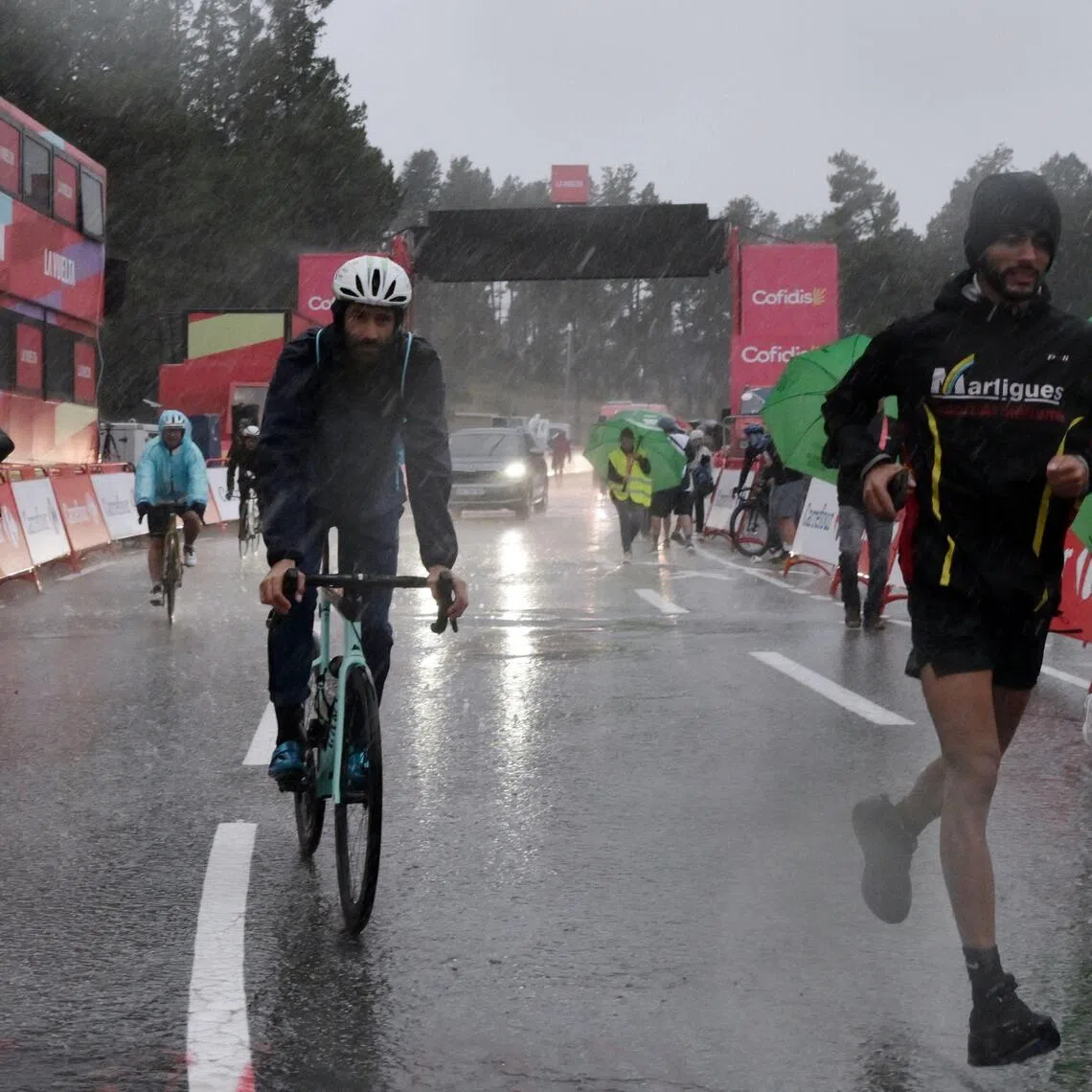 People leaving after a heavy hailstorm hit the finish area of the third stage of the Vuelta a Espana 2026 on Aug 24. The stage was abandoned inside the final few kilometres.