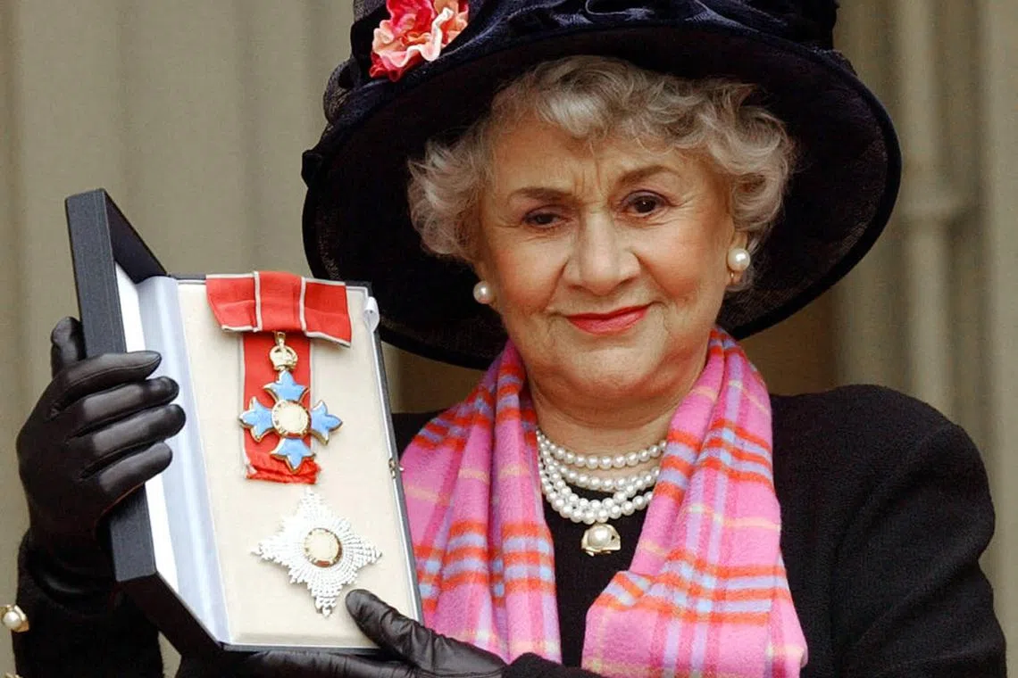 A 2004 photo shows British actress Joan Plowright posing for photos after being made a Dame by the Prince Of Wales at Buckingham Palace in London.