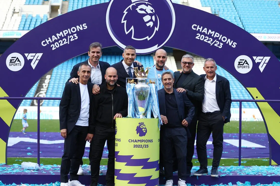 The Manchester City hierarchy celebrating with the Premier League trophy, one of three major titles that the team won this past season.