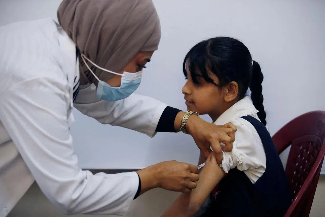 A schoolgirl receives a measles vaccine at a school in Iraq. 