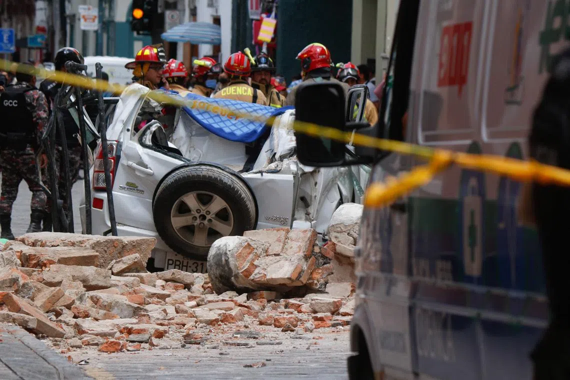 A wall collapsed onto a vehicle, killing one person, amid an earthquake, in the city of Cuenca, Ecuador. PHOTO: AFP