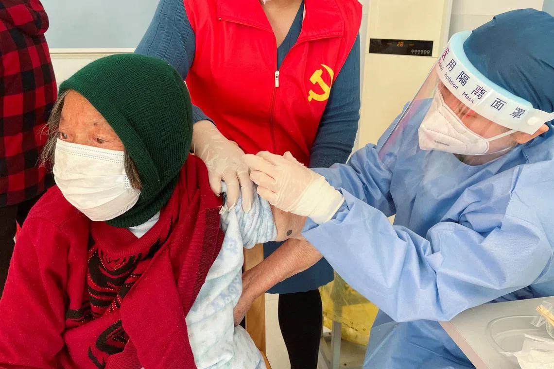 An elderly resident getting vaccinated during a visit to a vaccination center in Zhongmin village, China  on Dec 21, 2022. 