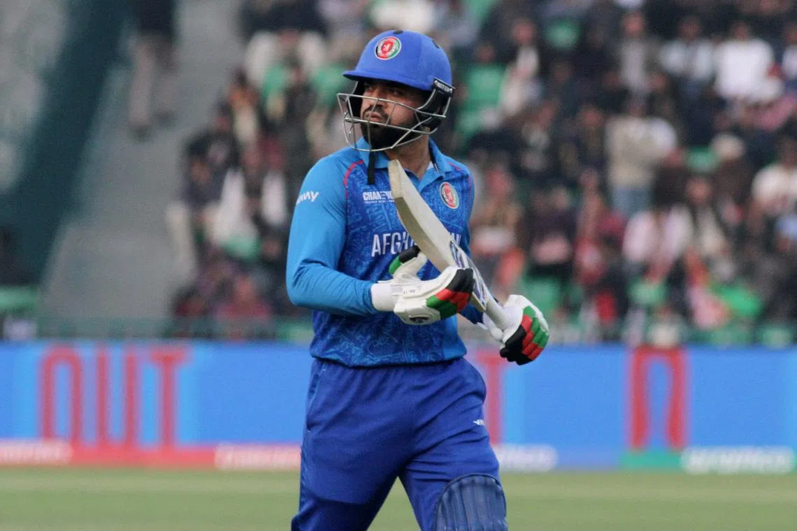 Cricket - ICC Men's Champions Trophy - Group B - Australia v Afghanistan - Gaddafi Stadium, Lahore, Pakistan - February 28, 2025  Afghanistan's Rashid Khan walks after losing his wicket, caught by Australia's Glenn Maxwell off the bowling of Ben Dwarshuis REUTERS/Asim Tanveer