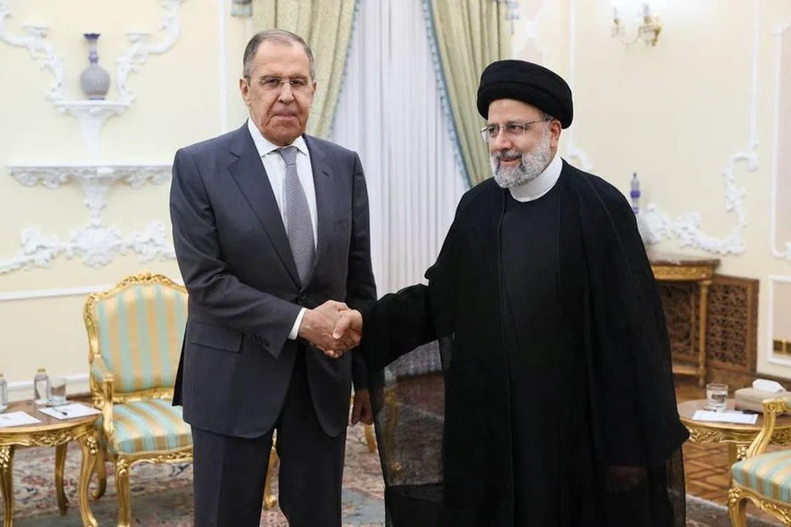 Russian Foreign Minister Sergei Lavrov shakes hands with Iranian President Ebrahim Raisi during a meeting in Tehran, Iran October 23, 2023. Russian Foreign Ministry/Handout via REUTERS