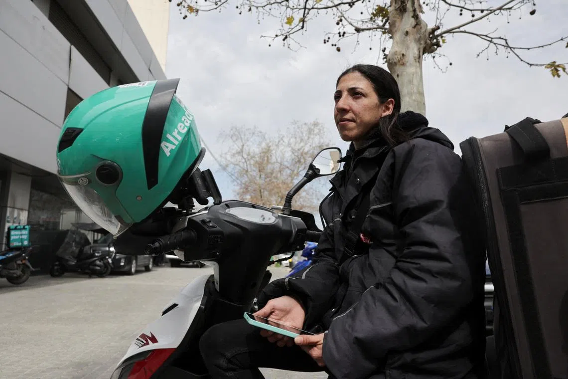 Marie Katanjian, who works as a delivery driver for the Toters delivery app, sits on her scooter in Beirut, Lebanon, March 18, 2026. REUTERS/Emilie Madi