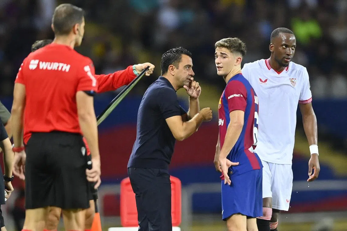 Barcelona coach Xavi speaking to midfielder Xavi during a Spanish La Liga match against Sevilla.
