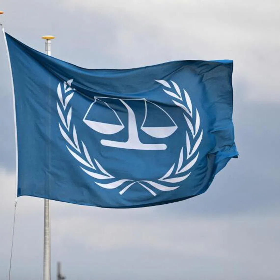 FILES) This photograph taken on March 14, 2025 shows a flag fluttering outside the International Criminal Court (ICC) in The Hague. Hungary's government announced on April 3, 2025 that it would withdraw from the International Criminal Court (ICC), just before Prime Minister Viktor Orban was to receive his Israeli counterpart Benjamin Netanyahu despite an ICC arrest warrant against him. Orban extended an invitation to Netanyahu last November, saying Hungary would not execute the warrant, a day after the ICC issued the arrest warrant against the Israeli premier over alleged war crimes in Gaza. (Photo by Nicolas TUCAT / AFP)