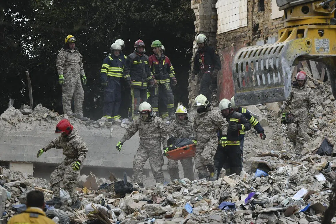 Ukrainian rescuers removing the body of a victim at the site of an overnight airstrike by Russia on a nine-storey residential building in Kyiv, on June 17.