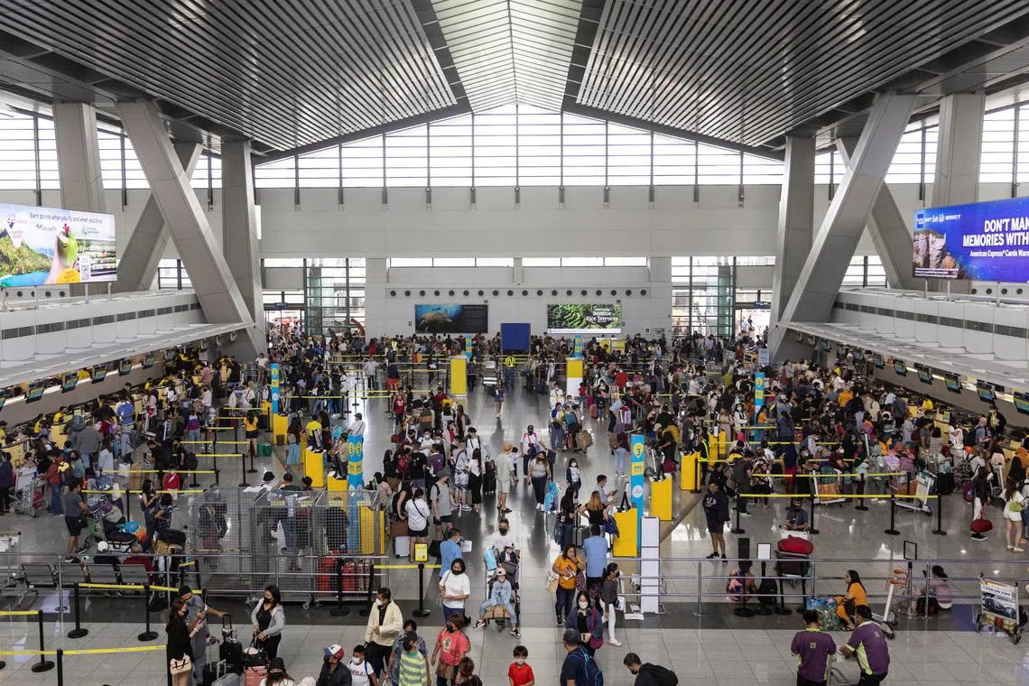 Passengers queue at airline counters in the Ninoy Aquino International Airport, in Metro Manila on Jan 2, 2023.