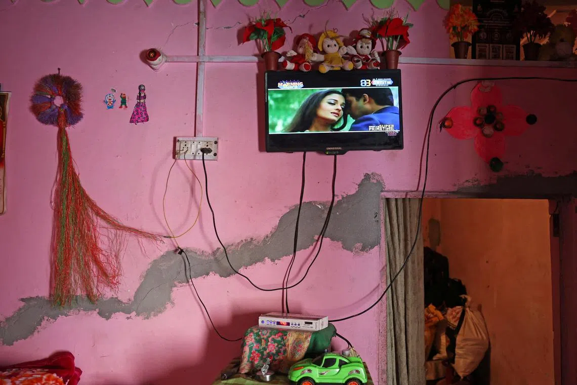 A television plays on the wall at the house of Rajeshwari Devi, 34, which developed cracks following rapid urban expansion, in the Gandhinagar area of Joshimath, in the northern state of Uttarakhand, India, Jan 16, 2023.