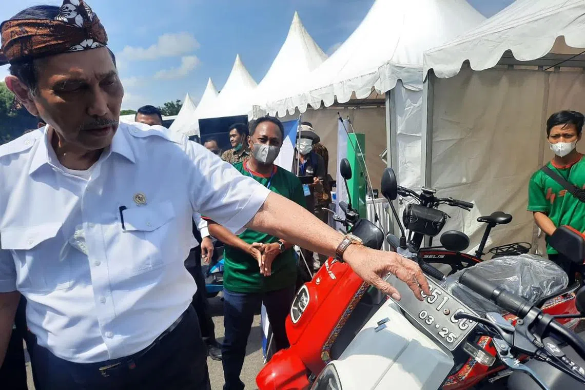 Indonesia's coordinating minister for maritime affairs and investment Luhut Pandjaitan, posing with one of PT Juara Bike's E-Max electric two wheelers last year.