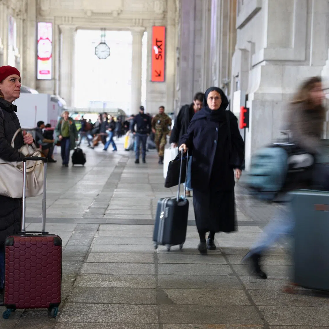 A woman looks at a board announcing delays at the Milan train station, as Italian police investigate possible sabotage to electricity cables near the city of Bologna that have caused delays to a large part of the national railway network, in Milan, Italy, February 7, 2026. REUTERS/Guglielmo Mangiapane
