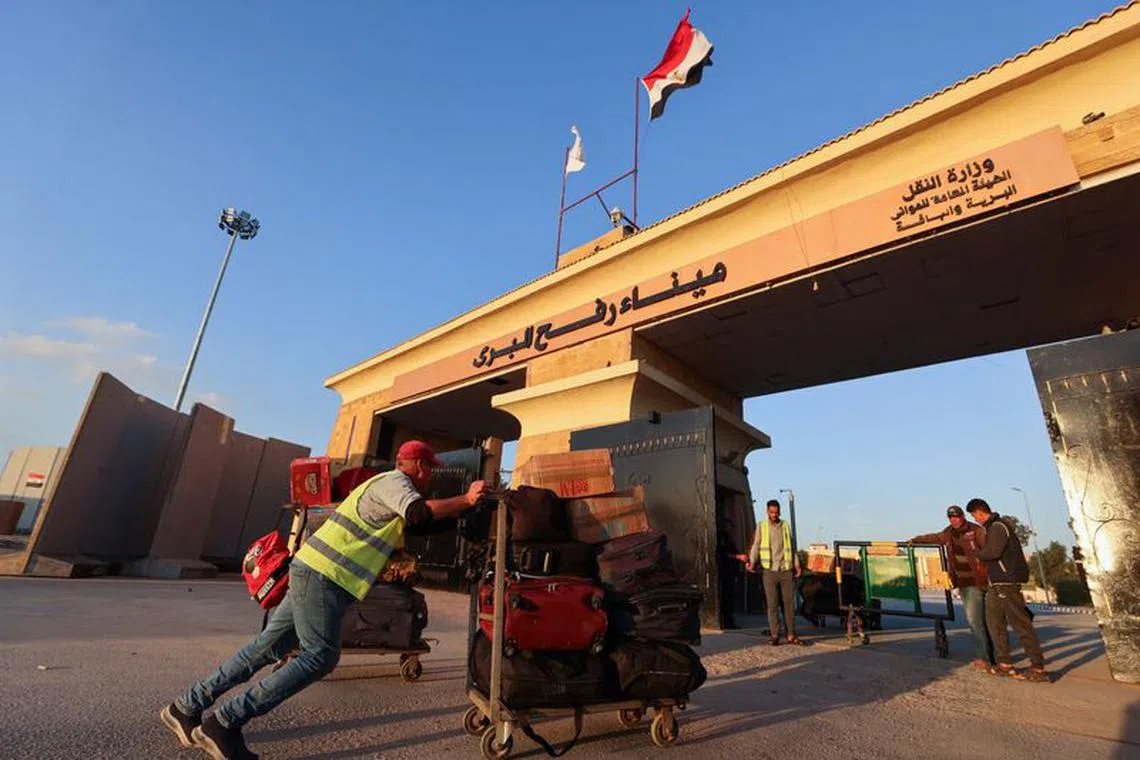 A worker pushes a luggage cart with belongings of Palestinians who are trying to get back into Gaza, at the Rafah border crossing between Egypt and the Gaza Strip, during a temporary truce between Hamas and Israel, in Rafah, Egypt, November 30, 2023.