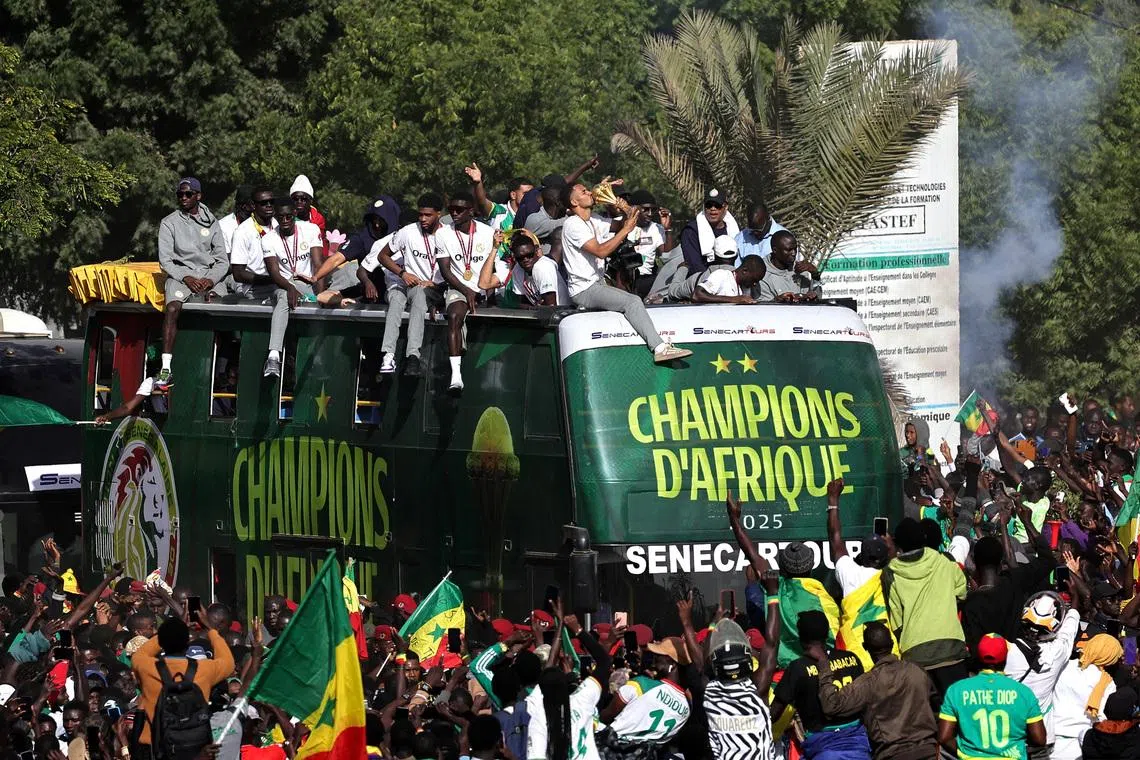 Soccer Football - CAF Africa Cup of Nations - Morocco 2025 - Final - Senegal Victory Parade - Dakar, Senegal - January 20, 2026 Senegal players and staff celebrate with the trophy on the bus during the victory parade REUTERS/Zohra Bensemra