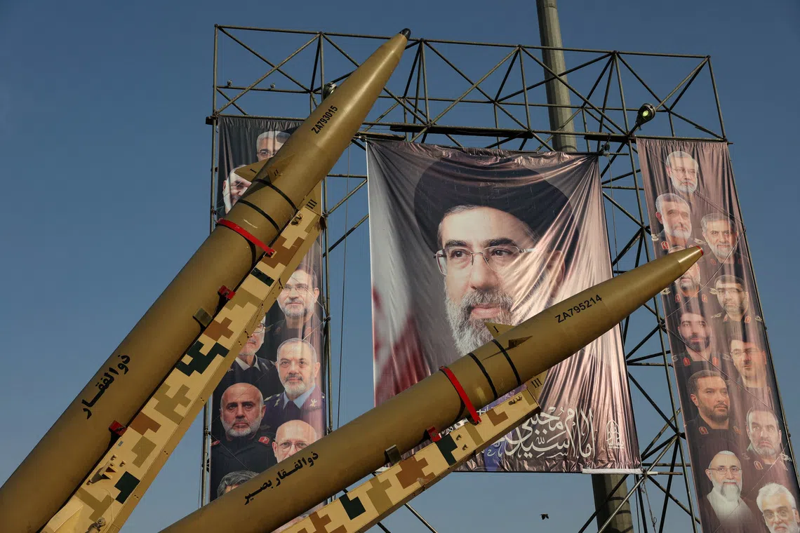 Iranian missiles are displayed next to a banner with a picture of Iran’s Supreme Leader Mojtaba Khamenei, on a street in Tehran, on Sept 27.