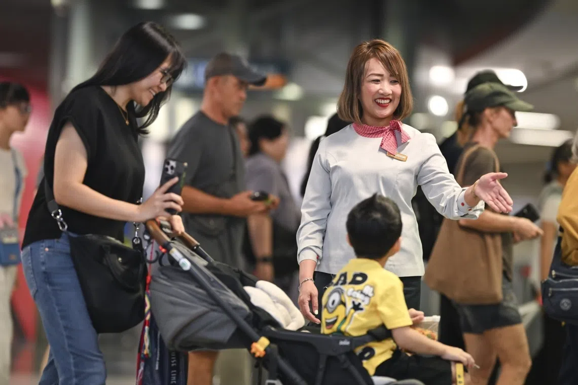 Susie Low, an assistant station manager, guiding commuters at an MRT station in Singapore