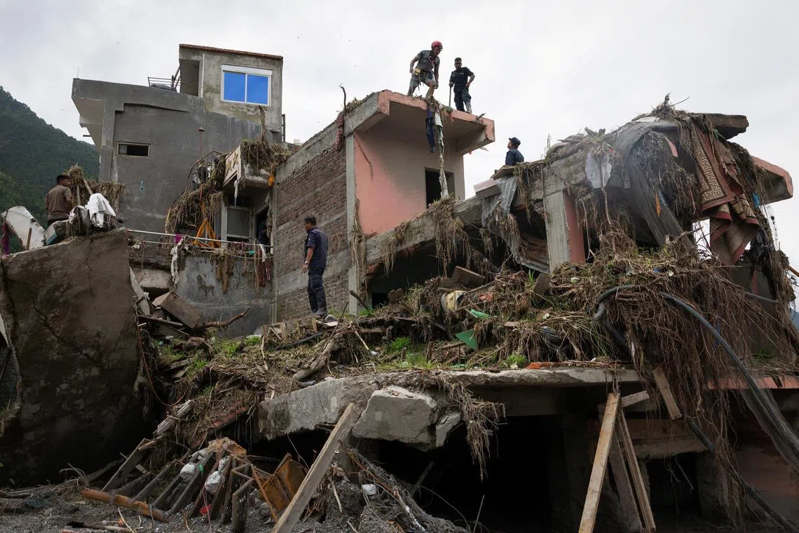 Nepal Police and Armed Police Force members search a house for survivors and victims in Betrawati, Nepal, on Sept 6.