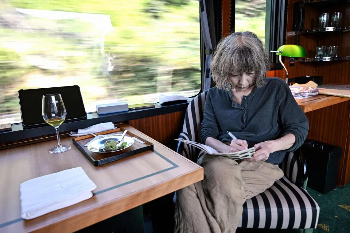 Japanese author Kaori Ekuni on Oct 22 working aboard the “Mizukaze” - a luxury train running from Kyoto to Matsue. Sixteen writers - half French-speaking and half Japanese - will collectively write a novel in under 24 hours during the ride.