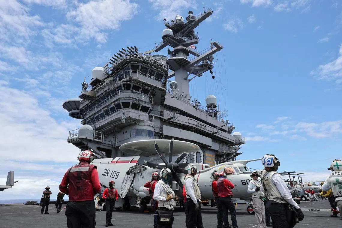 FILE PHOTO: Flight deck crew members watch jets take off from the USS Carl Vinson aircraft carrier during the Rim of the Pacific (RIMPAC) military exercises about 100 miles south of Oahu, Hawaii, U.S. July 19, 2024.  REUTERS/Marco Garcia/File Photo