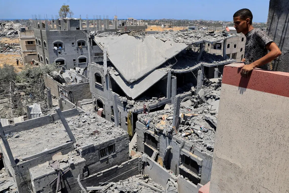 FILE PHOTO: A Palestinian inspects the damage on houses destroyed during an Israeli military operation, in Deir al-Balah, central Gaza Strip, July 23, 2025. REUTERS/Hatem Khaled/File Photo