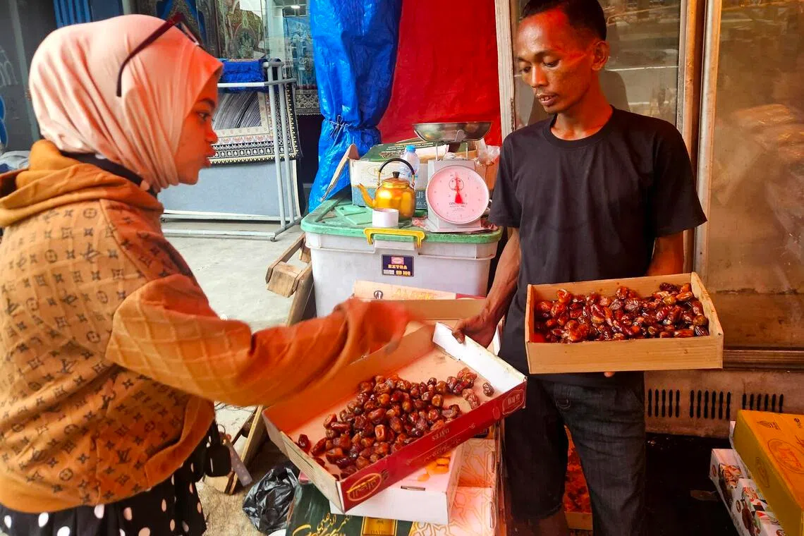 Ms Julaeha (left), who runs a home-based business, stuffs the dates she buys at Tanah Abang market with cheddar cheese and almonds, reselling them in decorative packaging.