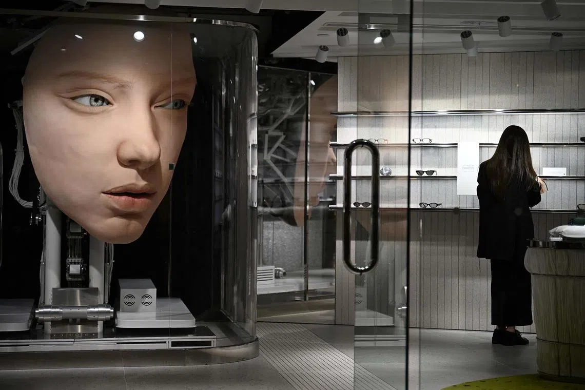 TOPSHOT - A mechanical face ‘looks’ at people in a boutique store in Hong Kong on April 16, 2025. (Photo by Peter PARKS / AFP)