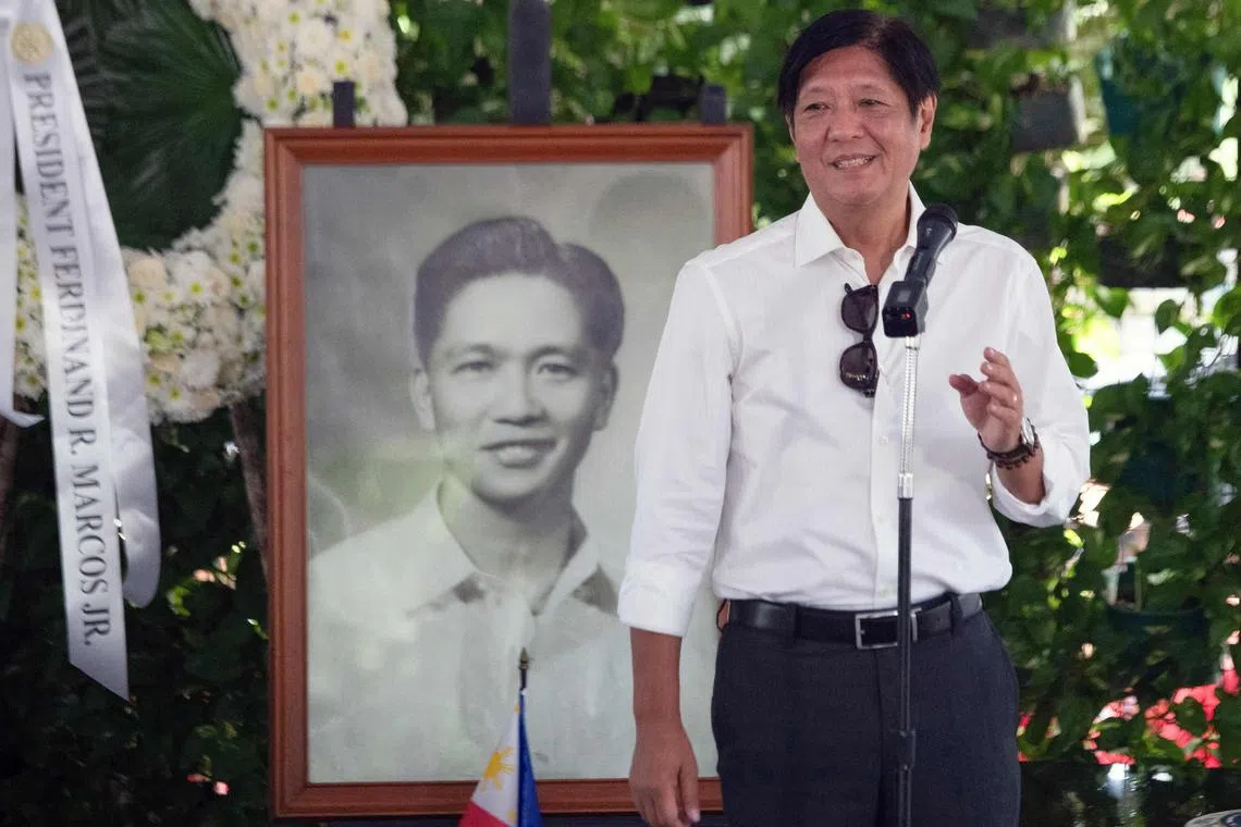 Philippine President Ferdinand Marcos Jr speaks beside a portrait of his father, the late dictator Ferdinand Marcos.