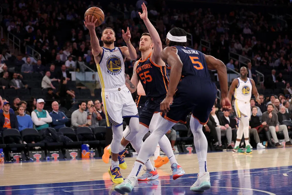 Golden State Warriors guard Stephen Curry drives to the basket against New York Knicks centre Isaiah Hartenstein and forward Precious Achiuwa during the third quarter at Madison Square Garden. 