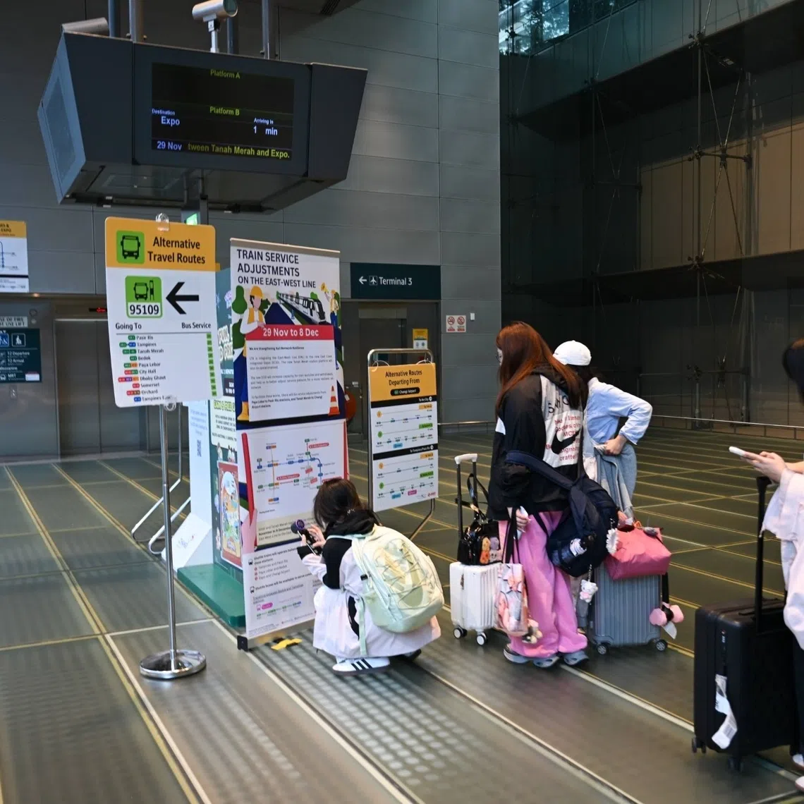 Tourists viewing signage about adjustments on the East West Line, at Changi Airport MRT station on Nov 29.
