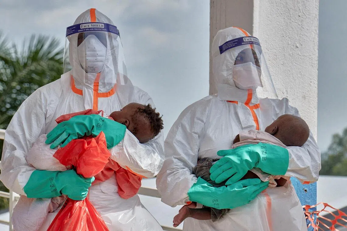 Congolese medical workers carrying children tested and cleared off from Ebola from Saint Nicholas orphanage on June 9.