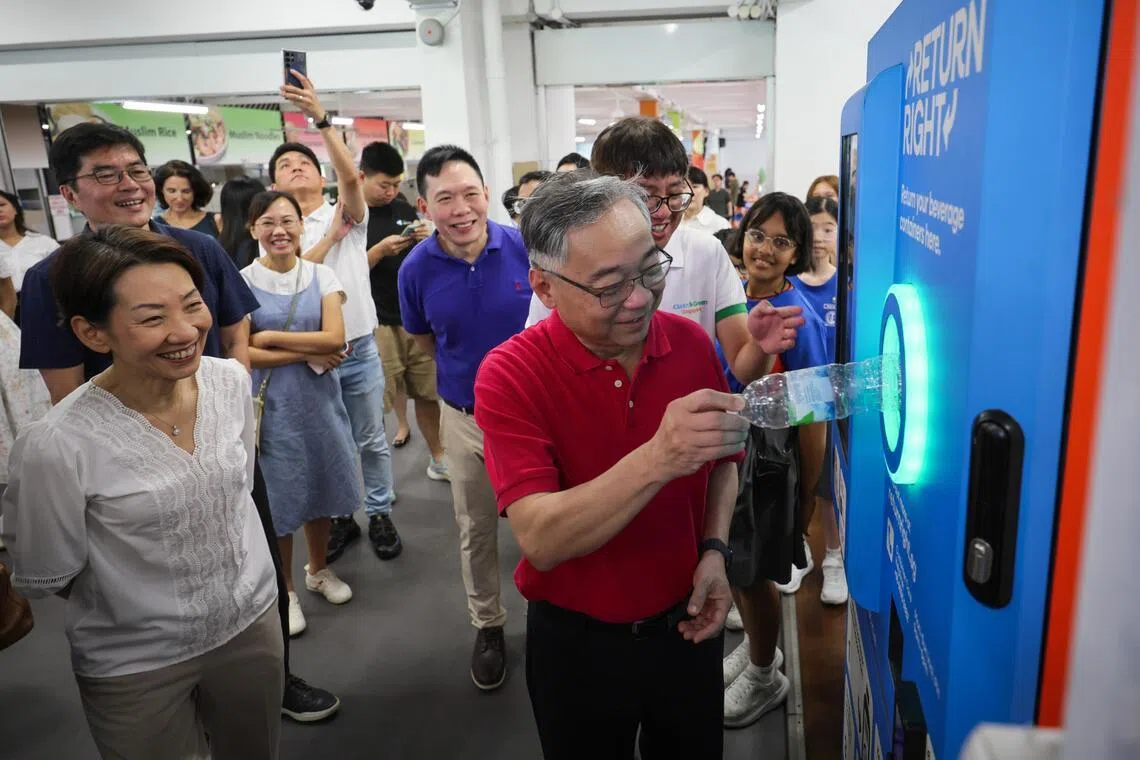 DPM Gan Kim Yong recycling a plastic bottle at a Return Right machine during a tour of exhibition booths at the launch of Go Green SG 2026 at Naval Base Primary School on May 11. 